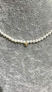 seed pearl necklace with 18k gold clasp and detail in the middle of the necklace; 16 inches; 6.93g